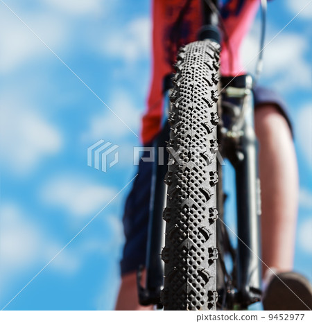 Mountain Bike and blue sky background. Focus on the front wheel. Mountain Bike and blue sky background. Focus on the front wheel. 9452977