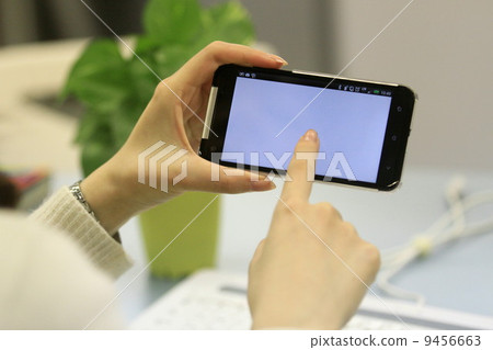 Woman holding a smartphone 9456663