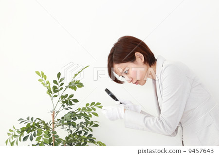 A woman looking with a magnifying glass 9457643