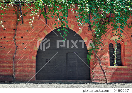 Red brick house with wooden door in Italy. 9460937