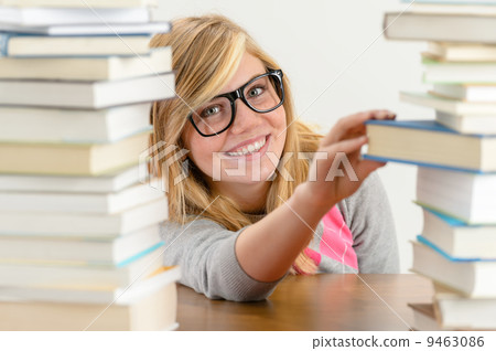 Smiling student girl take book from stack 9463086