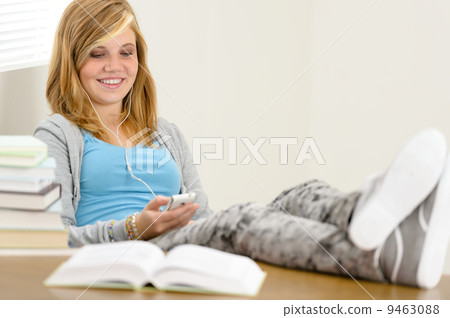 Smiling student teenager relaxing legs on table Smiling student teenager relaxing legs on table 9463088