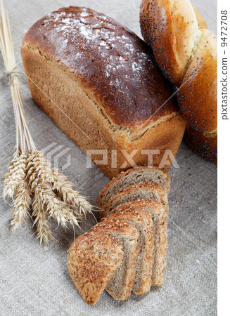 Fresh bread with ears of wheat on the canvas. 9472708