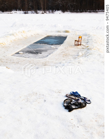 slippers and chair near ice hole in frozen lake slippers and chair near ice hole in frozen lake 9475405