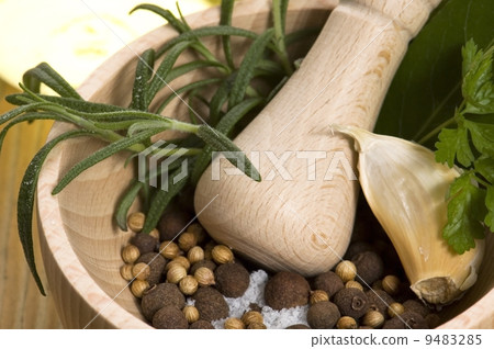 Mortar with fresh herbs and allspice berries 9483285