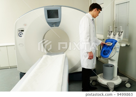 Young doctor standing near computed tomography scanner in a hospital 9499863