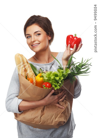 Smiling brunette woman with grocery bag full of fresh vegetables and red paprika Smiling brunette woman with grocery bag full of fresh vegetables and red paprika 9499884