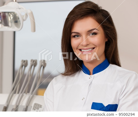 Young beautiful brunette female dentist at dentist's surgery 9500294