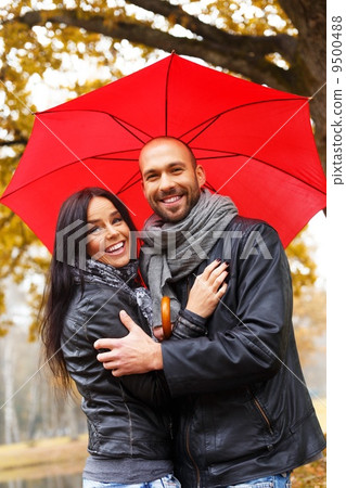 Happy middle-aged couple with umbrella outdoors on beautiful rainy autumn day Happy middle-aged couple with umbrella outdoors on beautiful rainy autumn day 9500488