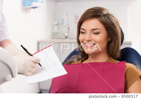 Beautiful young brunette woman visiting dentist 9500517