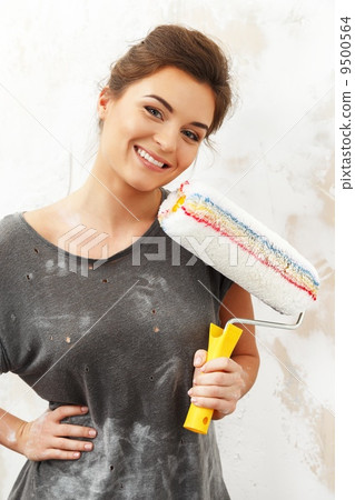 Happy beautiful young woman doing wall painting 9500564