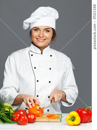 Beautiful young woman cook cutting fresh paprika Beautiful young woman cook cutting fresh paprika 9501386