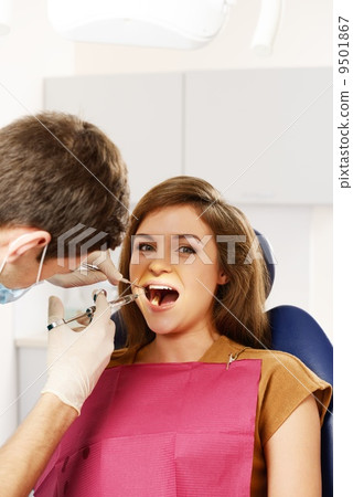 Dentist making anaesthetic injection to woman patient Dentist making anaesthetic injection to woman patient 9501867