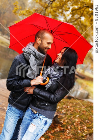 Happy middle-aged couple with umbrella outdoors on beautiful rainy autumn day Happy middle-aged couple with umbrella outdoors on beautiful rainy autumn day 9501963