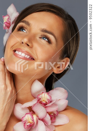 Young beautiful brunette woman with orchid flowers 9502322