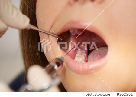 Dentist making anaesthetic injection to woman patient 9502591