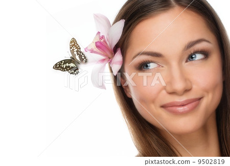 Young brunette girl with beautiful smile and butterfly sitting on orchid flower in her hair 9502819