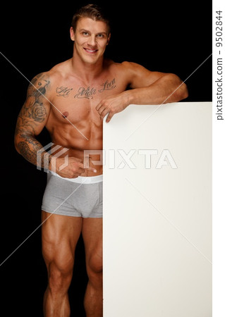 Man with athletic muscular body holding blank notice board Man with athletic muscular body holding blank notice board 9502844