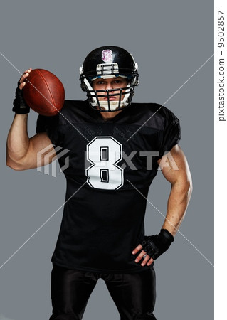 American football player with ball wearing helmet and jersey American football player with ball wearing helmet and jersey 9502857