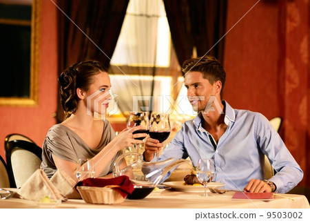 Beautiful young couple with glasses of wine in restaurant Beautiful young couple with glasses of wine in restaurant 9503002