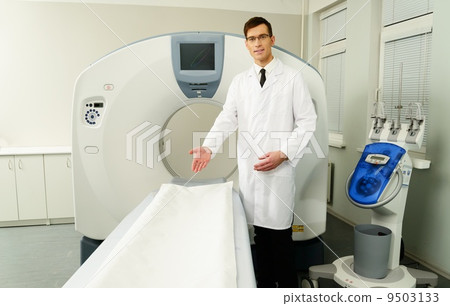 Young doctor standing near computed tomography scanner in a hospital Young doctor standing near computed tomography scanner in a hospital 9503133