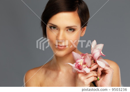 Young beautiful brunette woman with orchid flowers 9503236