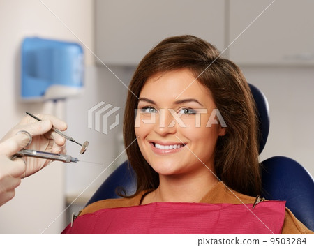 Dentist making anaesthetic injection to woman patient 9503284