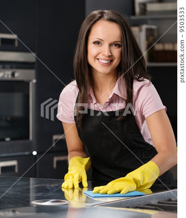 Beautiful cheerful brunette woman in gloves cleaning modern kitchen Beautiful cheerful brunette woman in gloves cleaning modern kitchen 9503533