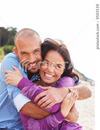 Happy smiling middle-aged couple on a beach 9503539