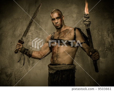 Wounded gladiator holding torch and sword covered in blood Wounded gladiator holding torch and sword covered in blood 9503661