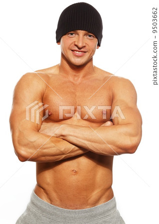 Handsome man with muscular torso in beanie hat posing 9503662