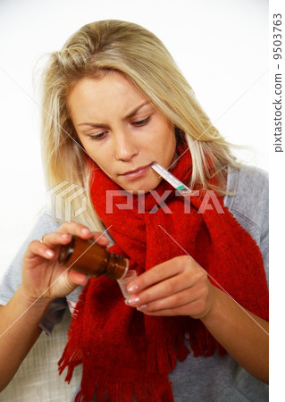 Sick young blond woman with thermometer bottle of mixture 9503763