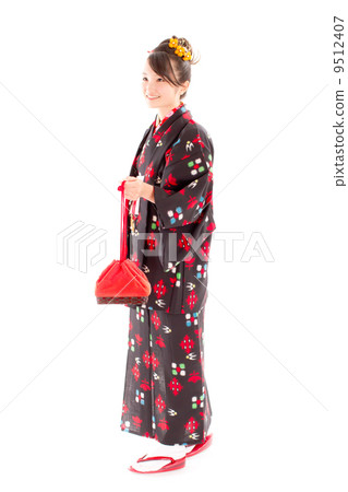 一個可愛的女孩穿著和服穿著合奏束帶袋在手 9512407
