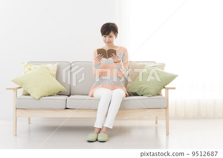 A young woman reading a book in a reading room 9512687