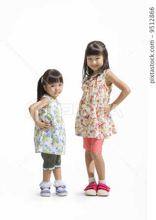 Sisters standing with their hands on their waist 9512866