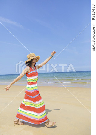 一個女人在沙灘上散步 9513453