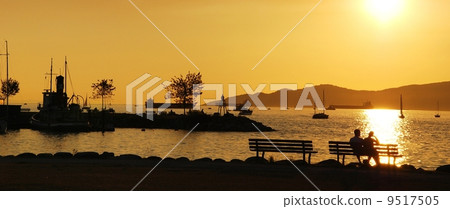 Silhouette of a couple enjoy beautiful sunset view in English Bay, Silhouette of a couple enjoy beautiful sunset view in English Bay, 9517505