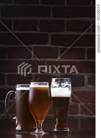 Glass of light beer on a dark pub. 9520655