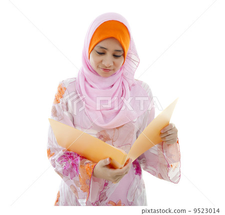 malay muslim girl reading from a folder malay muslim girl reading from a folder 9523014