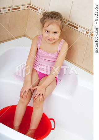 Girl holding his feet in cold water. Harden Girl holding his feet in cold water. Harden 9523358