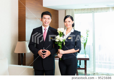 Asian Chinese hotel manager welcoming VIP guests 9523886