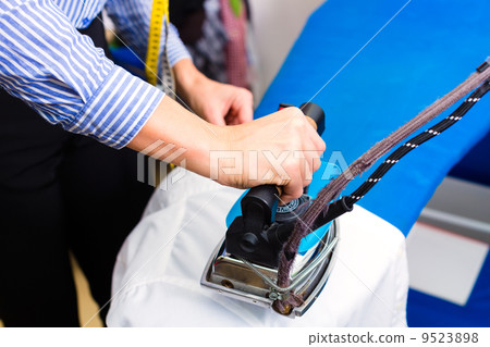 Cleaner in laundry shop ironing jacket 9523898