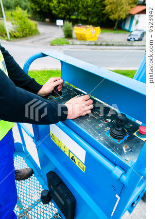 Crane driver driving hydraulic lifting ramp with control desk Crane driver driving hydraulic lifting ramp with control desk 9523942