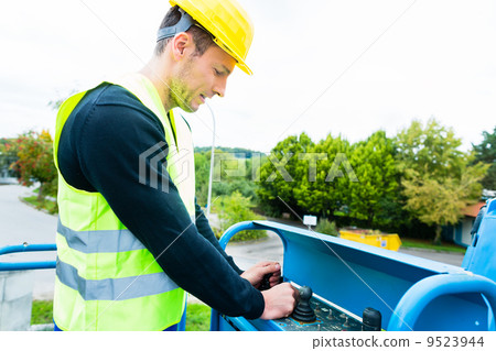 Crane driver driving hydraulic lifting ramp with control desk Crane driver driving hydraulic lifting ramp with control desk 9523944