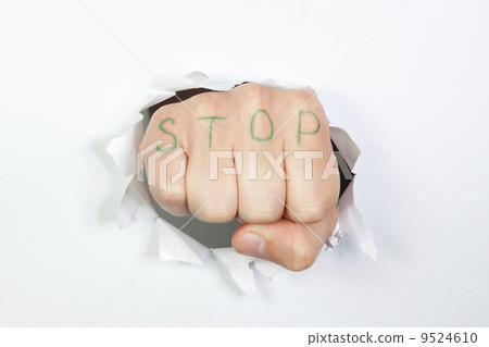 Fist of the hole in the paper that says stop. Fist of the hole in the paper that says stop. 9524610