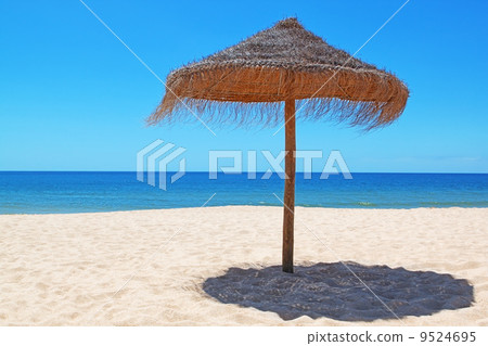 Wooden umbrella on the beautiful Portuguese beach. Wooden umbrella on the beautiful Portuguese beach. 9524695