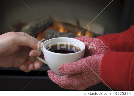 Hand warming at a fireplace 9525254