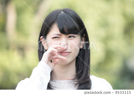 A woman suppressing her nose 9533115