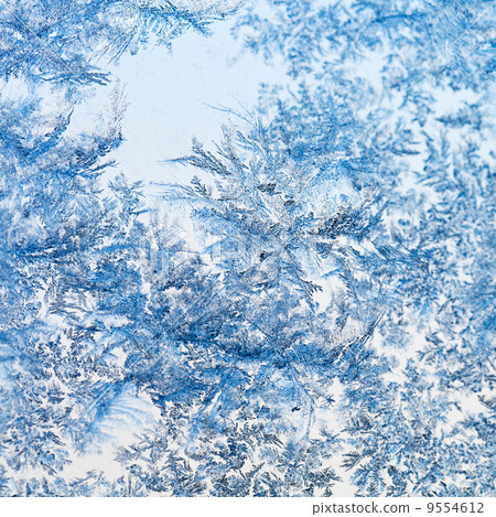 snowflakes and frost pattern on glass close up 9554612