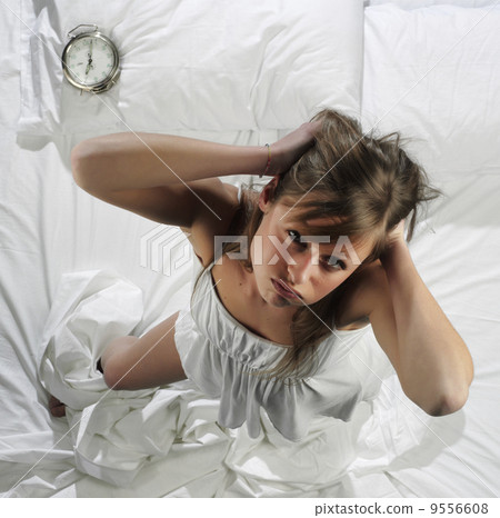 Woman in bed with alarm clock Woman in bed with alarm clock 9556608